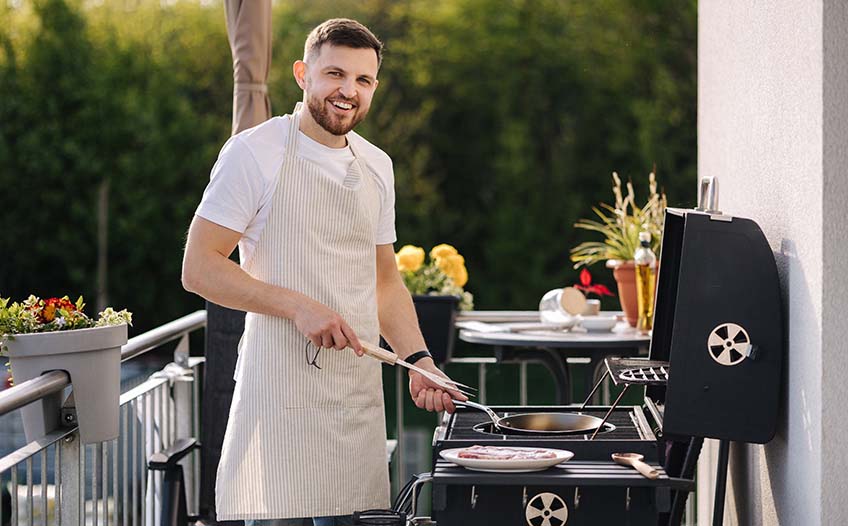 Mężczyzna przygotowuje potrawy na grillu