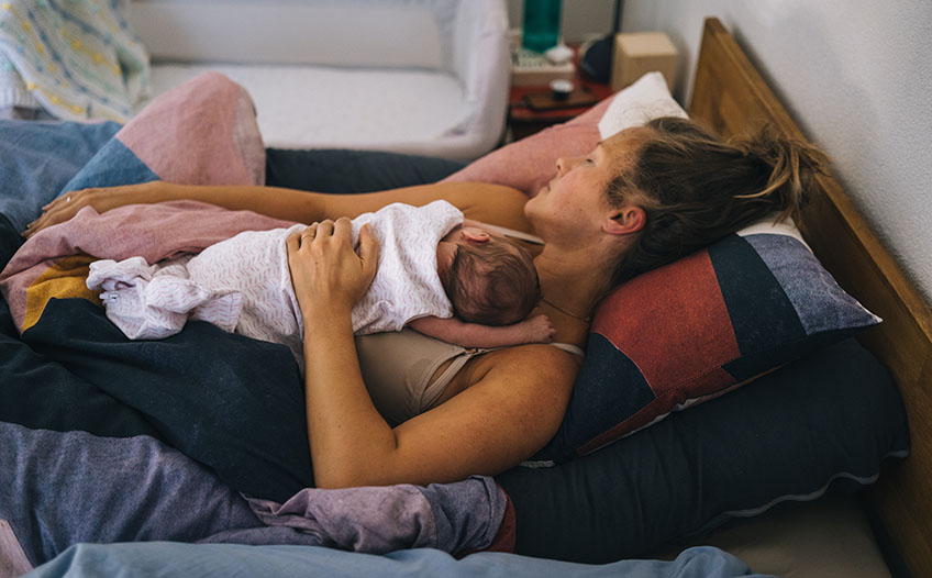 Mama śpi z niemowlęciem w sypialnianym łóżku