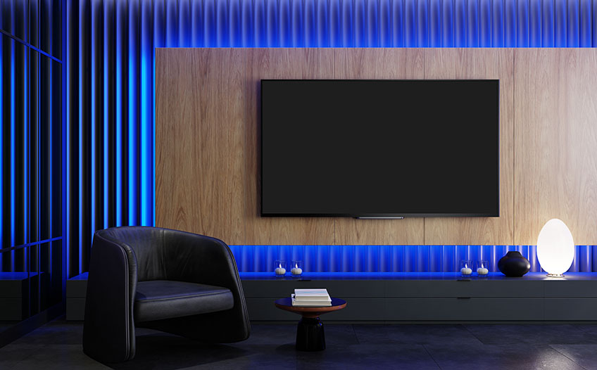 Duży telewizor do kina domowego, w tle podświetlone na niebiesko panele