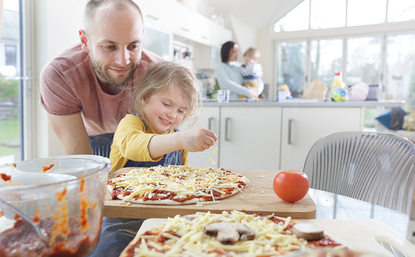 Tata z córką przygotowują wspólnie domową pizzę